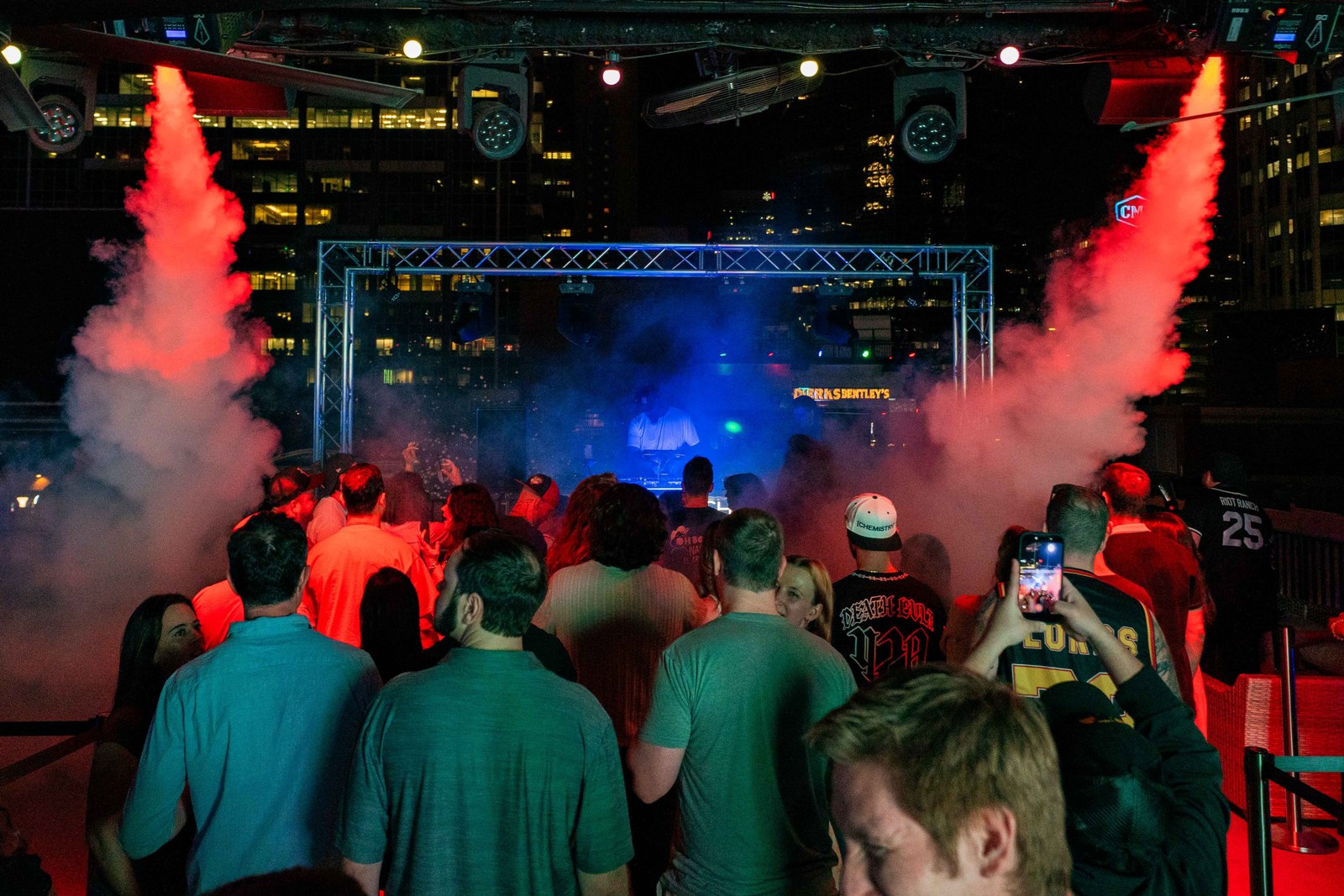 A crowd gathered around a stage under dramatic lighting in downtown Nashville.